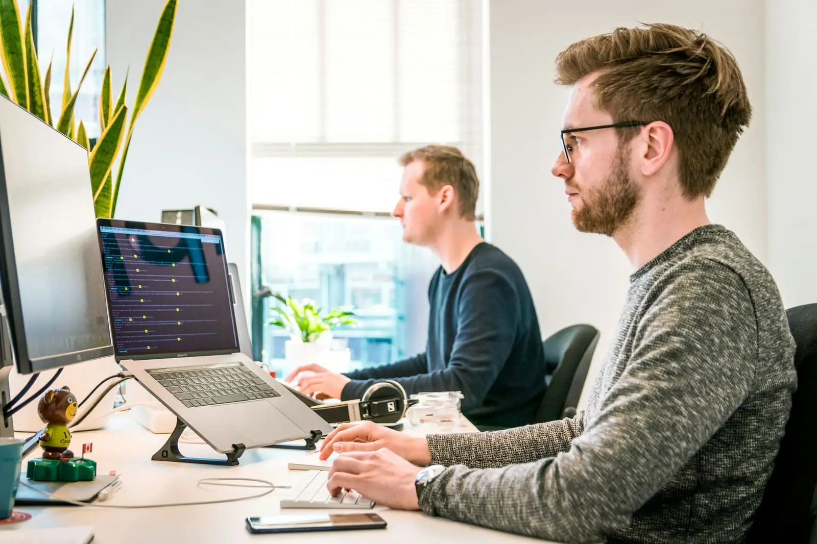 Two developers working at computers in a bright office